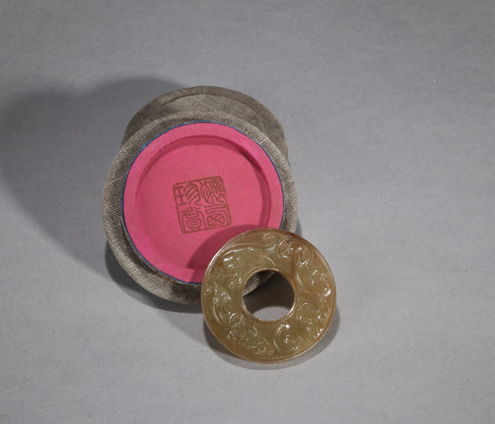 A JADE BI DISC WITH CHILONG: A jade bi disc carved with a chilong. Diam. 5.5 cm.