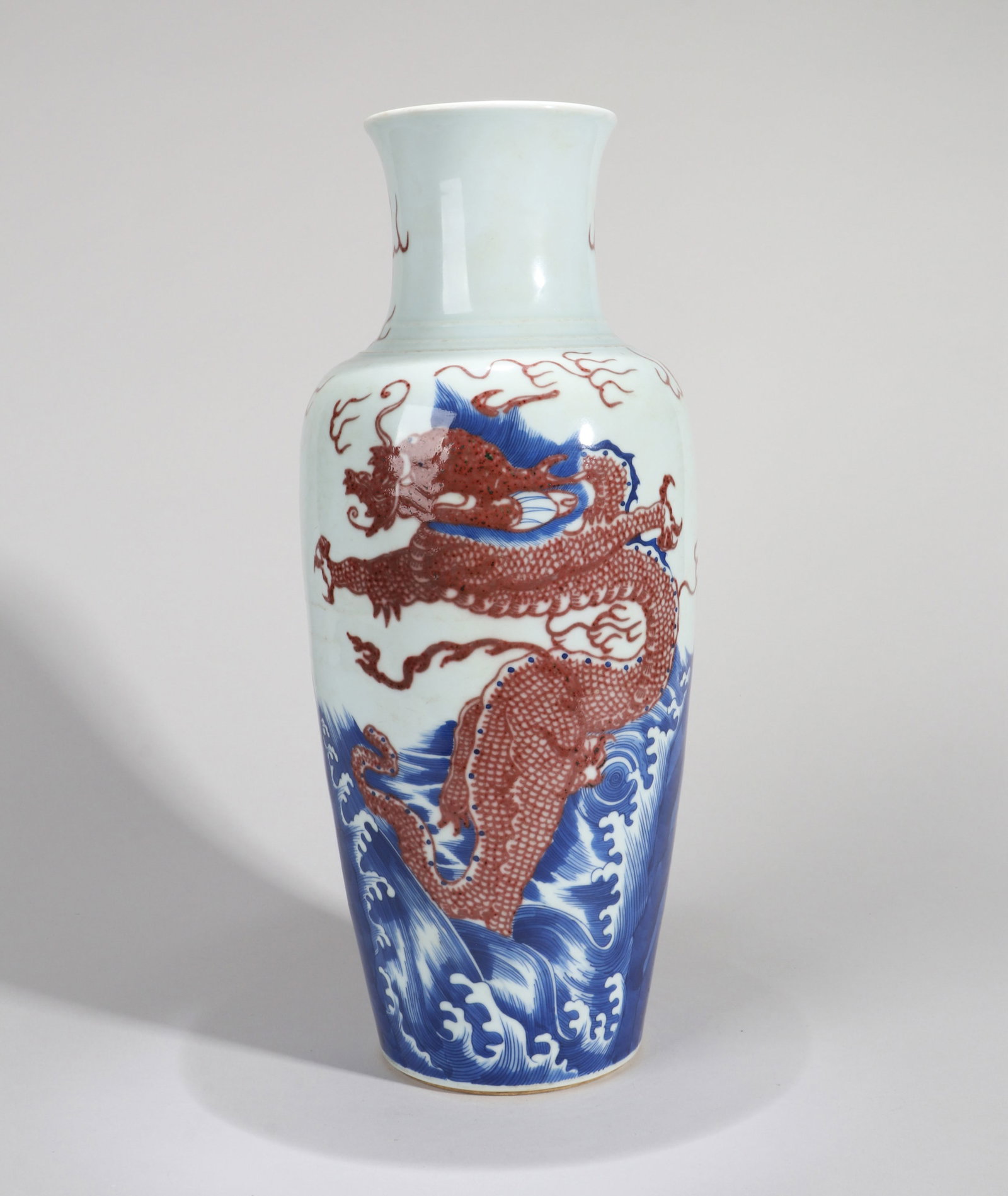 A BLUE-AND-WHITE AND UNDERGLAZE-RED 'DRAGON AMID WAVES AND CLOUDS' GUANYIN VASE (1 of 9)