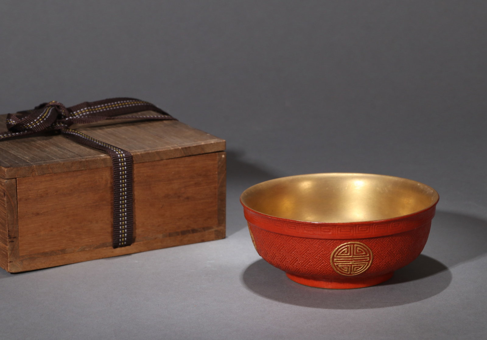A PORCELAIN BOWL IMITATING CARVED RED LACQUER: A porcelain bowl molded and decorated in imitation of carved red lacquer. Diameter 11 cm, height 4.5 cm.