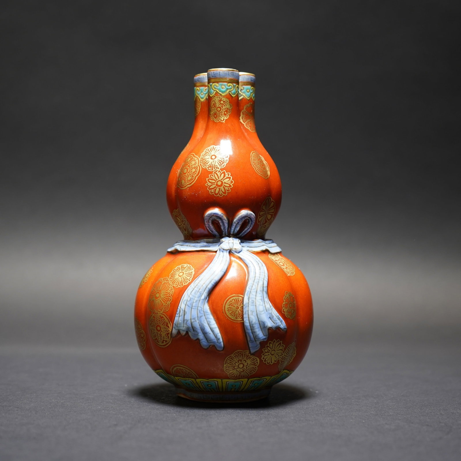 A GOLD-DECORATED CORAL-GROUND DOUBLE-GOURD VASE: A gold-decorated coral-ground double-gourd vase. H16 x 8.5 cm