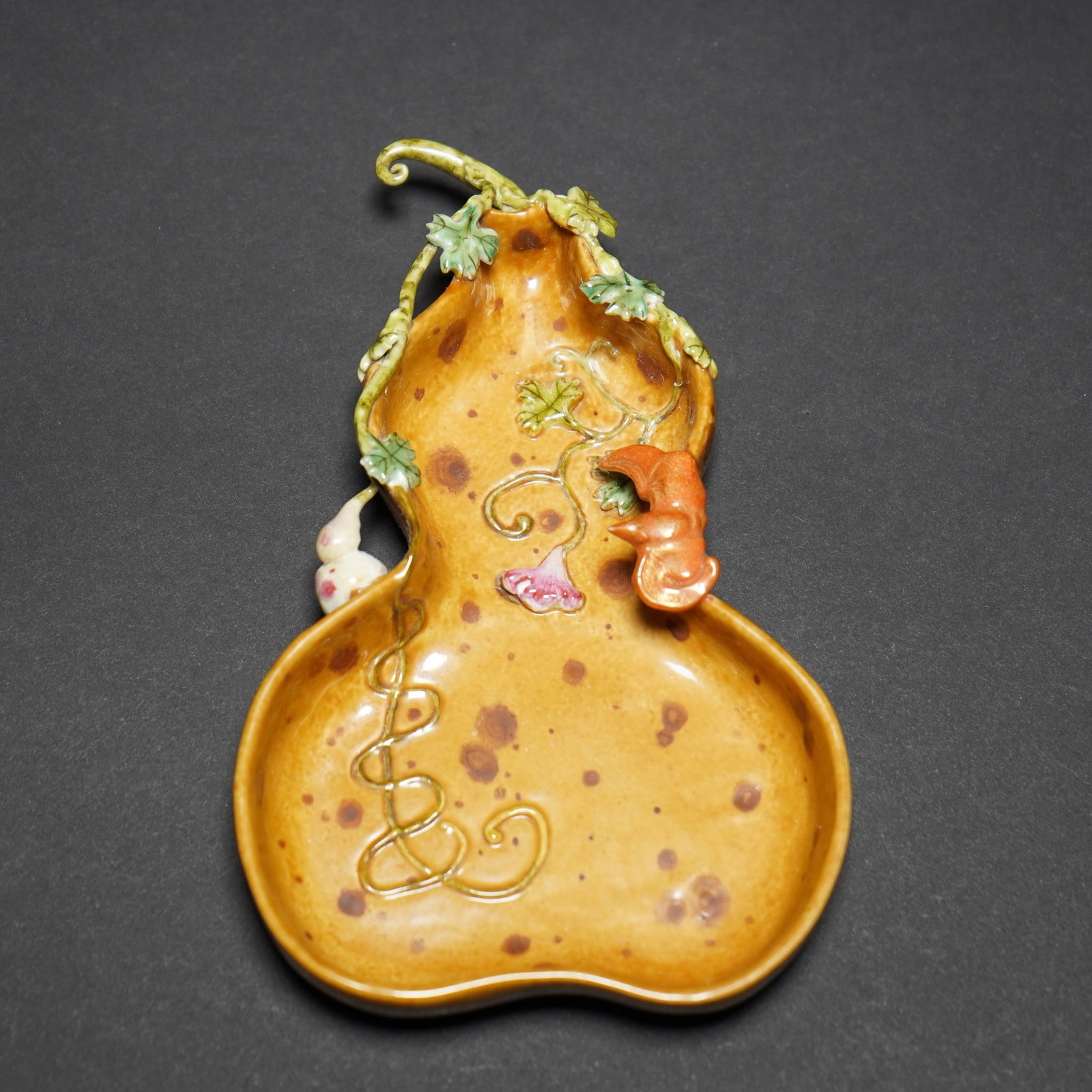 A FAMILLE-ROSE DOUBLE-GOURD-FORM DISH, YONGZHENG MARK: A famille-rose double-gourd-form dish, Yongzheng mark, decorated with applied gourd vines and fruit. 15.3 x 9.4 cm