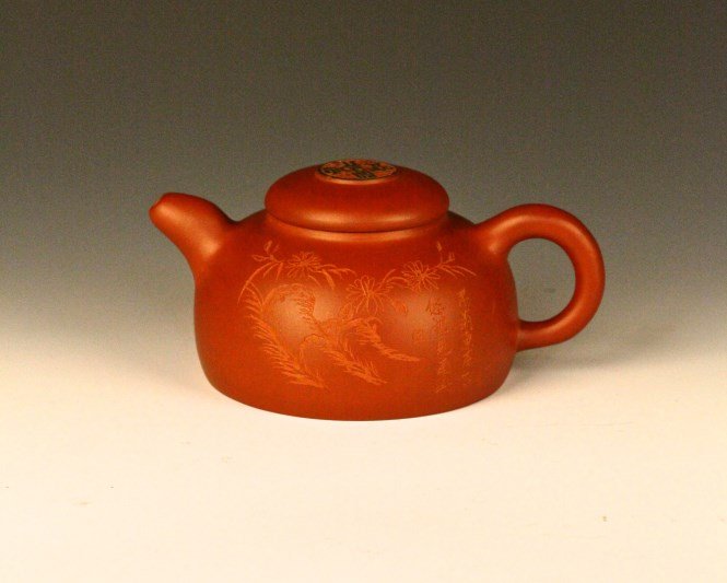 A Chinese Clay Yixing Teapot: An antique Chinese clay Yixing Teapot, with carving of grape vine, green and pink tinted, flowery and foliate ornaments on lid, with delicate decorative band surrounding opening. Signature He Fengtang