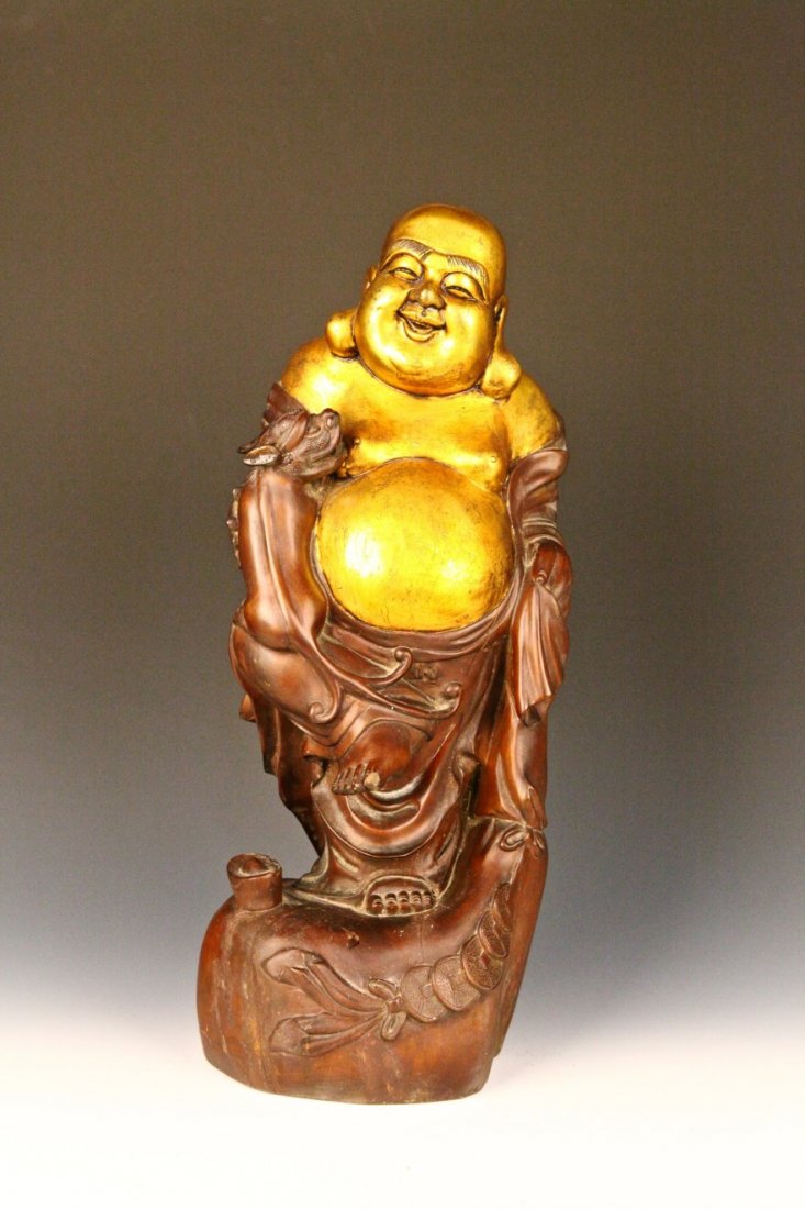 Chinese Carved hardwood smiling Buddha: Carved hardwood smiling Buddha with gold detailing covering his face and body, featuring elongated earlobes and an ample belly. Height 19"