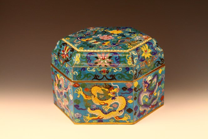 A Hexagon Shaped Cloisonne Enamel Box: A cloisonne enamel hexagon shaped box and cover. Each of the six sides of the box decorated with a dragon. Length 11"