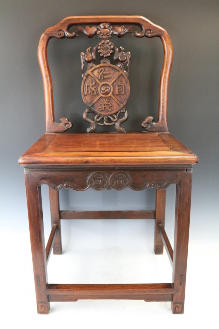 A Huanghuali and Mixed Wood Chair: A gleaming Huanghuali and mixed Rosewood chair from the Qing dynasty period masterfully carved featuring magical bats and Tao symbols in the back of the chair.