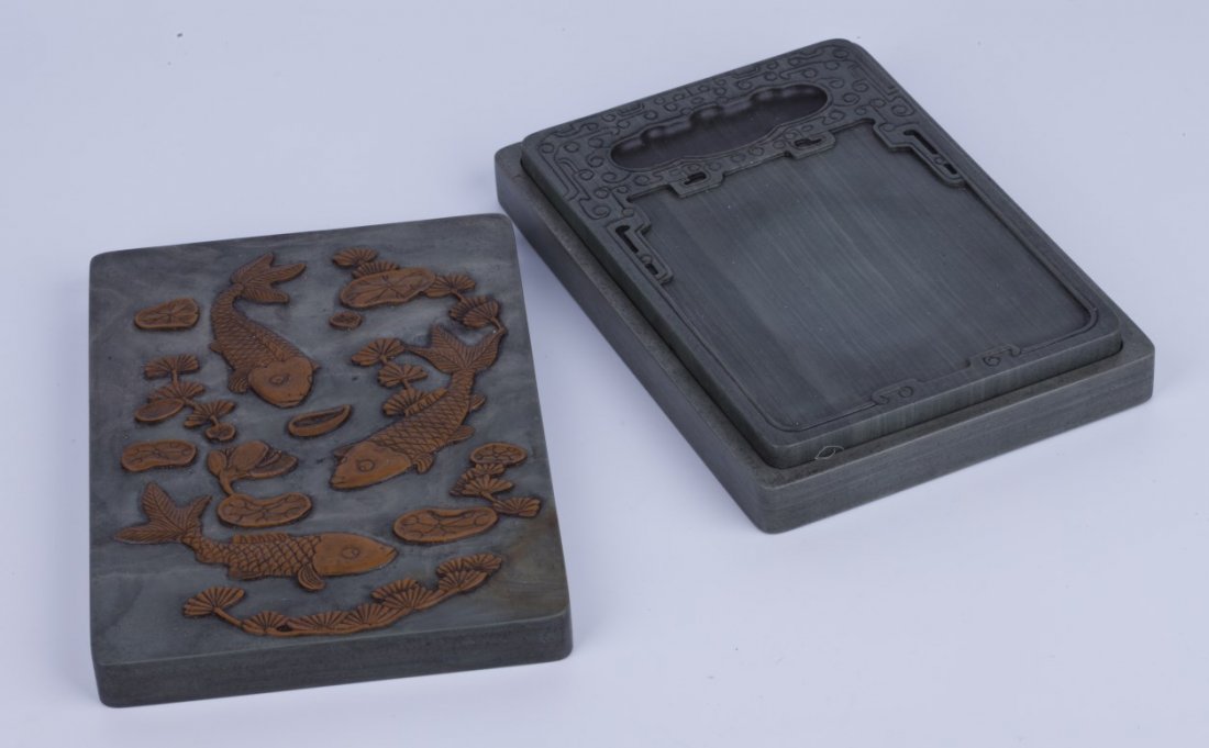 Chinese Duan ink stone with koi design: Chinese Duan ink stone with carved koi pond design cover, with three koi fishes and lily pads of dark caramel color, inscription on the back, comes with box. Length 6.5" Width 4.25" Height 0.75"