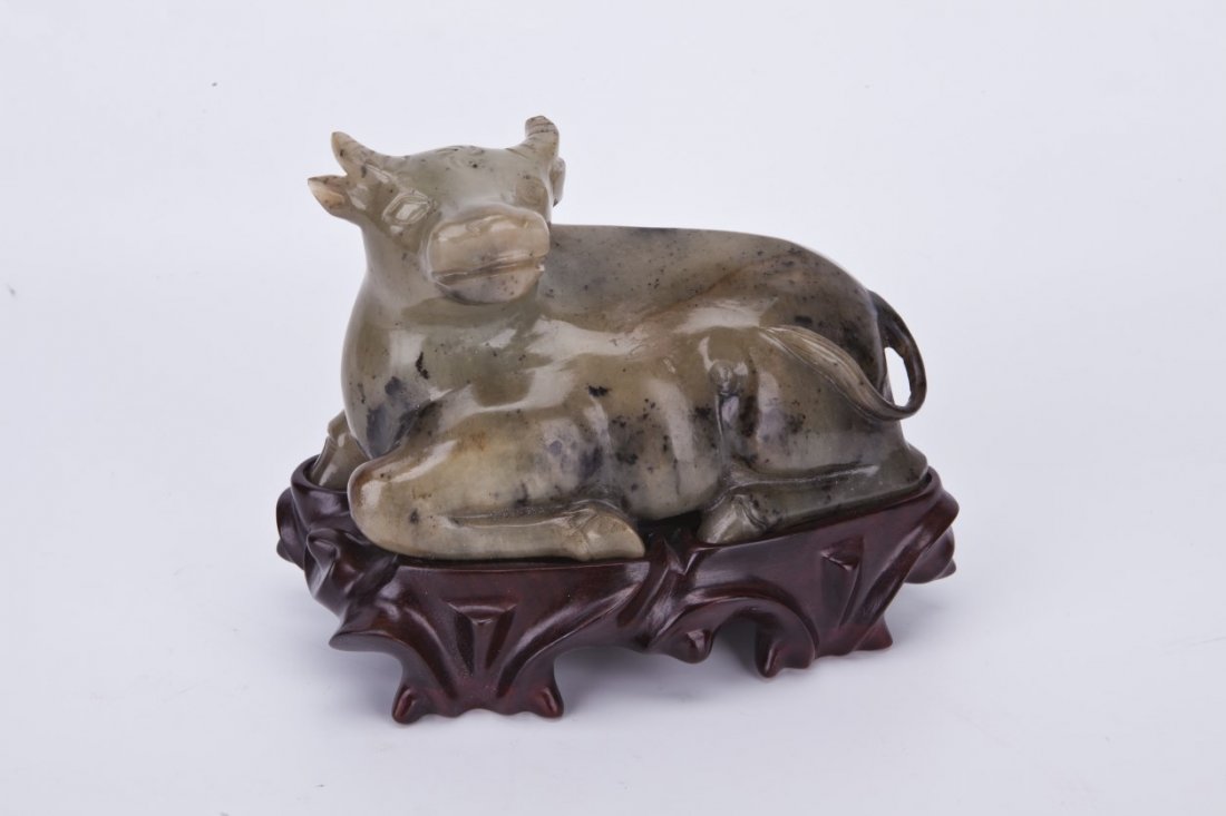 Chinese Antique White Jade Ox Statue: Chinese Antique White Jade Ox Statue with charcoal colored suffusions resting on a wooden stand. Unusual color and theme. Length 6" Height 4"