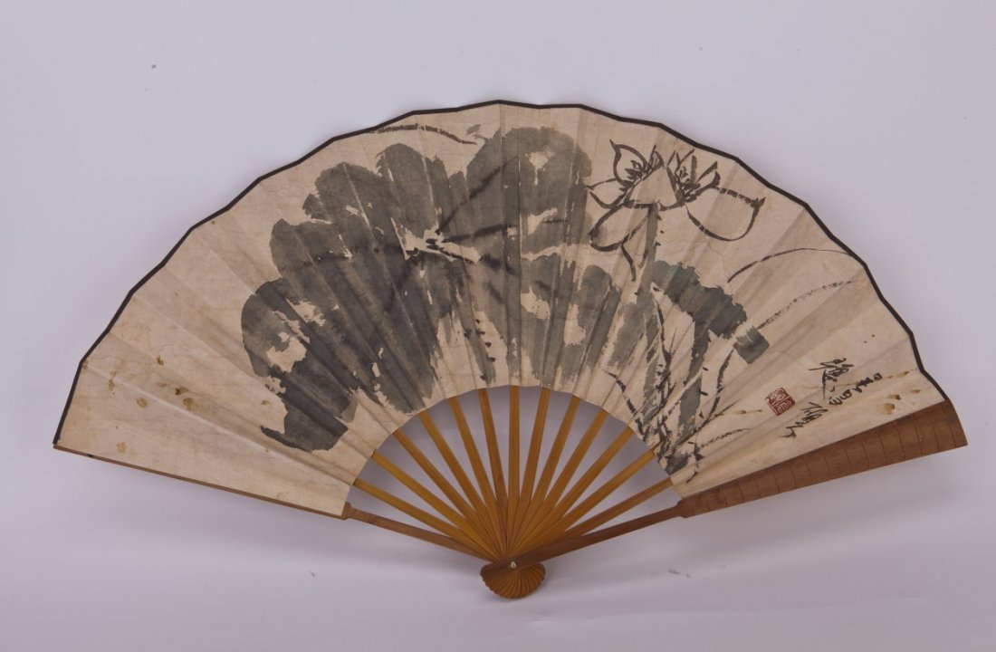 Chinese Fan Painting: Chinese Fan Painting, depicting lotus flower on one aide and Chinese characters on the other side, signature after Wu Changshuo. Length 13" Width 23.5"