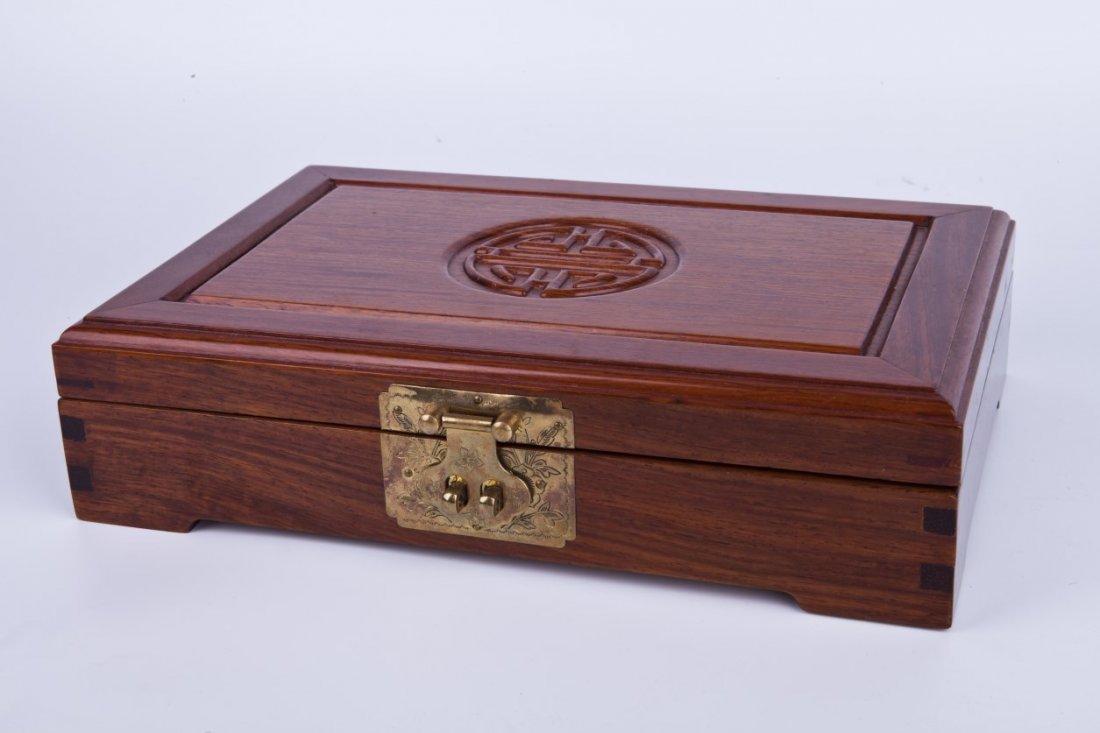 Chinese rosewood jewelry box: Chinese rosewood jewelry box; with inlaid details to cover; metal latch closure with floral design; of rich brown and caramel coloration; of rectangular form. Length 12" Width 8" Height 3"