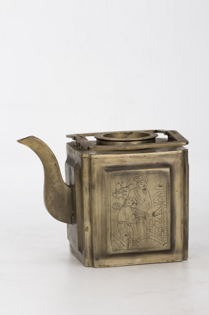 Metal tea pot with filter: Metal tea pot with a metal filter, of rectangular shape, with the design of figures on both the front and back panel of the tea pot. Length 5.5" Width 3.75" Height 4.25"