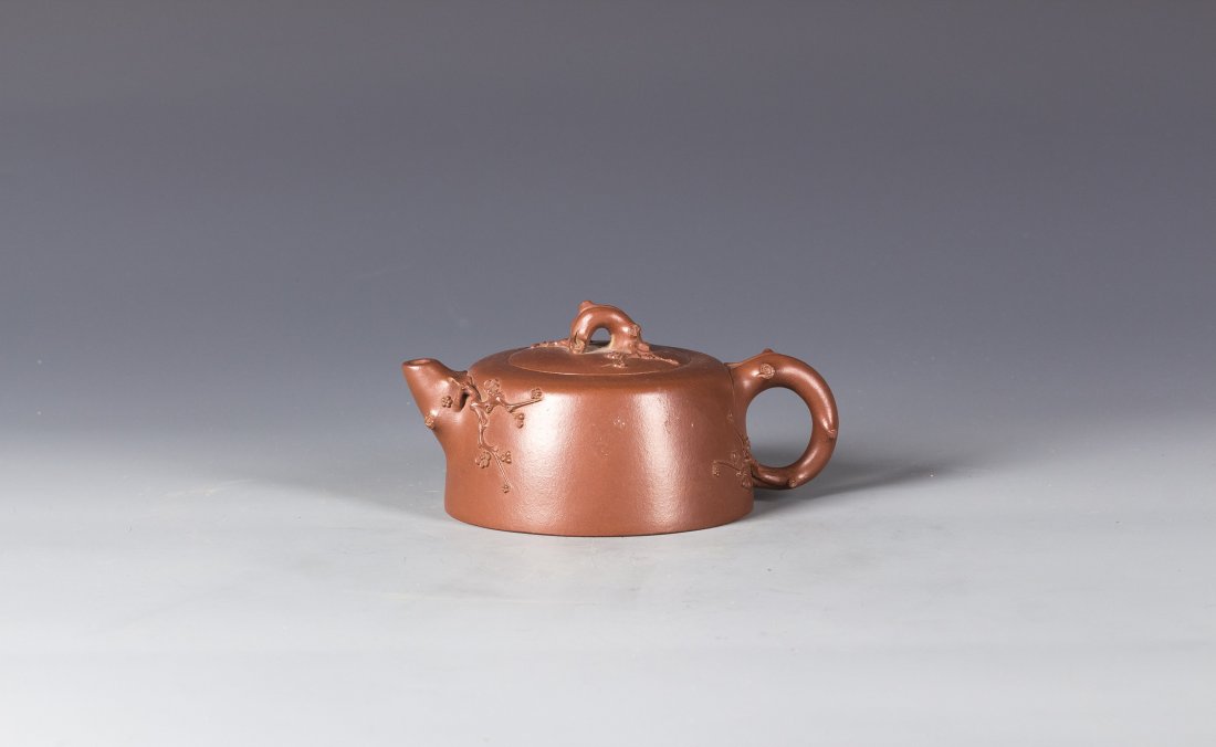 Chinese Yixing Zisha Teapot: Chinese Yixing Zisha clay Teapot, carved the plum flowers around the top , mouth and handle. Mark with three calligraphy characters on the bottom. Length 5.5" Height 4"