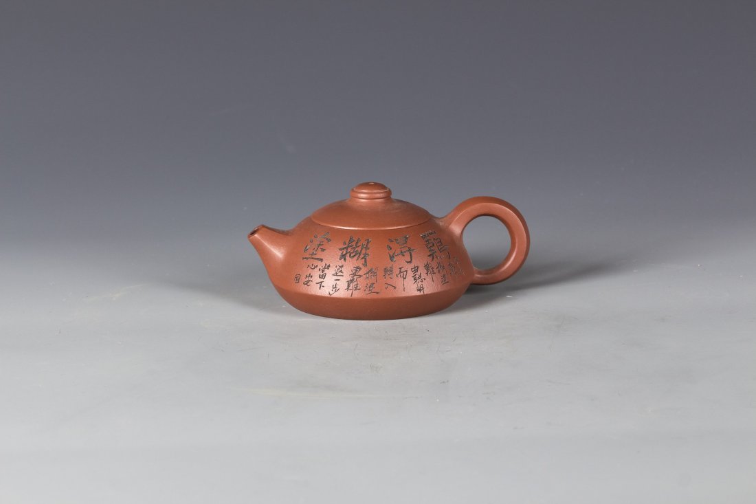 Zisha Teapot by HONG Jun: A Big-Ring-Shaped-Handle Zisha Teapot by HONG Jun, with Chinese Calligraphy and Bamboo pattern, Bottom Signed and Sealed. Length 6'' Width 4'' Height 3''