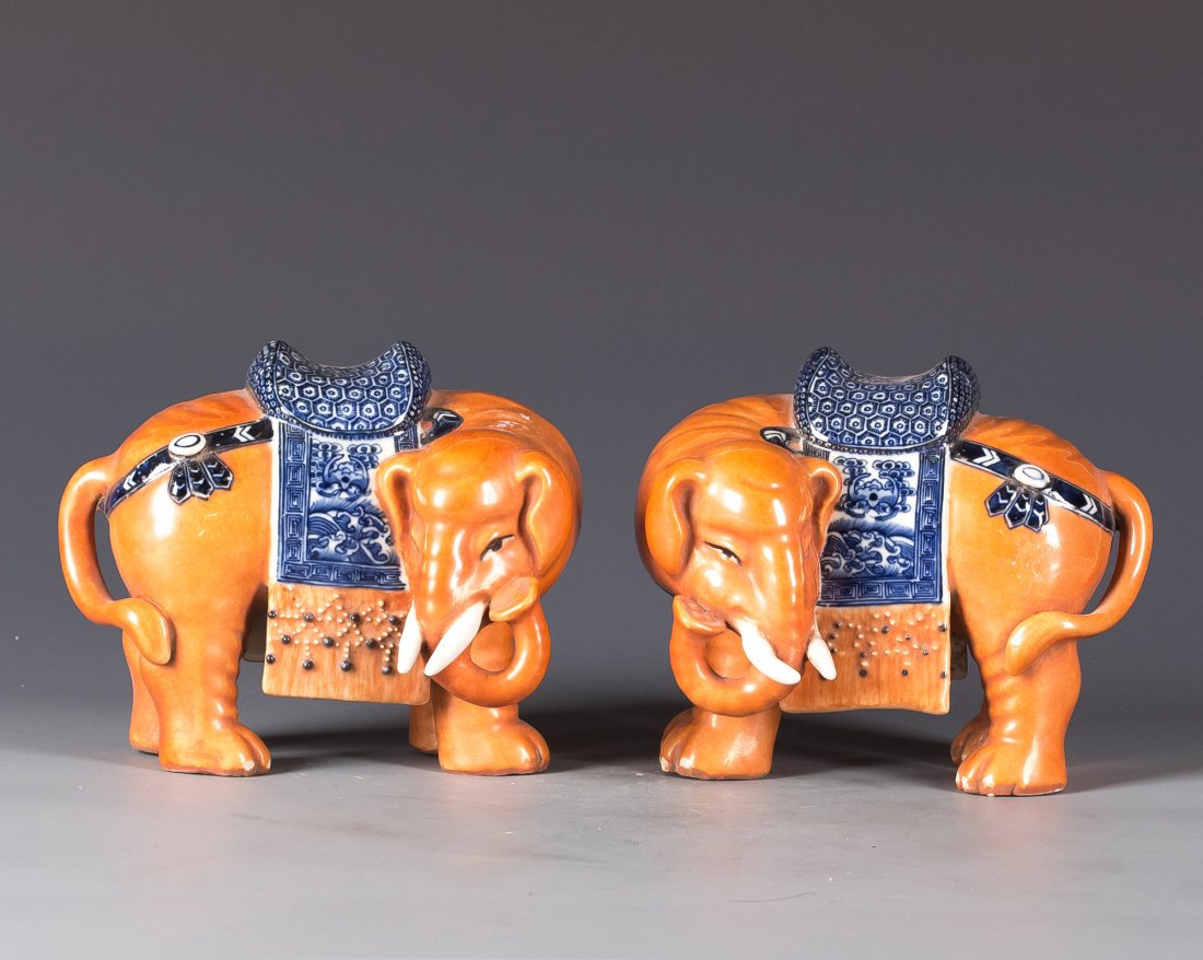 PAIR OF PORCELAIN ELEPHANT: A pair of Porcelain Elephant, in orange glaze, decorated with Blue and White glaze on its saddle, an auspicious titled front facing. Length 7” Width 5.25” Height 6.25”