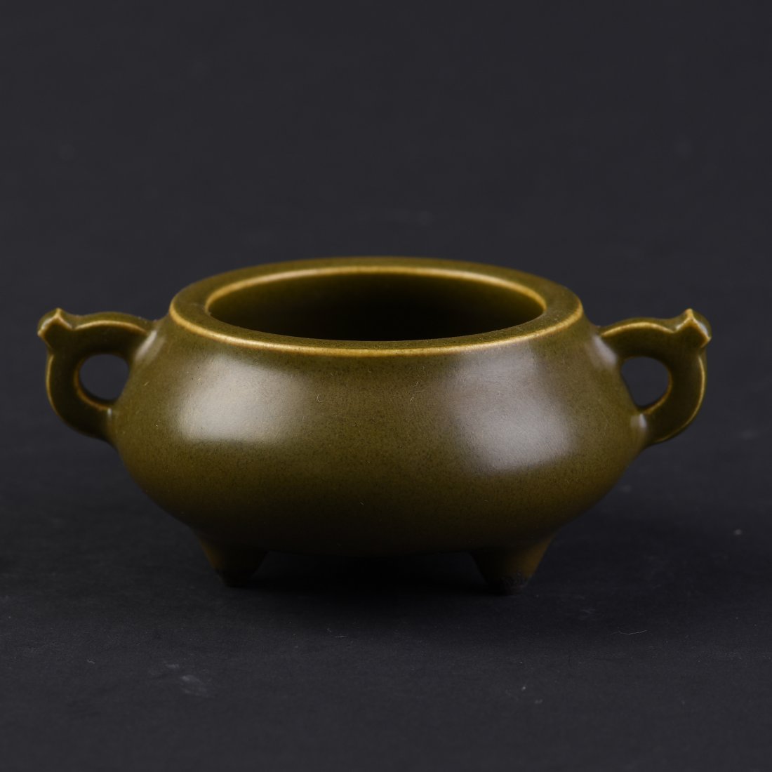 A Globular Porcelain Censer: A globular porcelain censer casted with a wide rim flange above a shallow cylindrical body with a flat base and two handles. Four-character seal casted on the base. Height1.75" Length 4.5" Width 3.25"