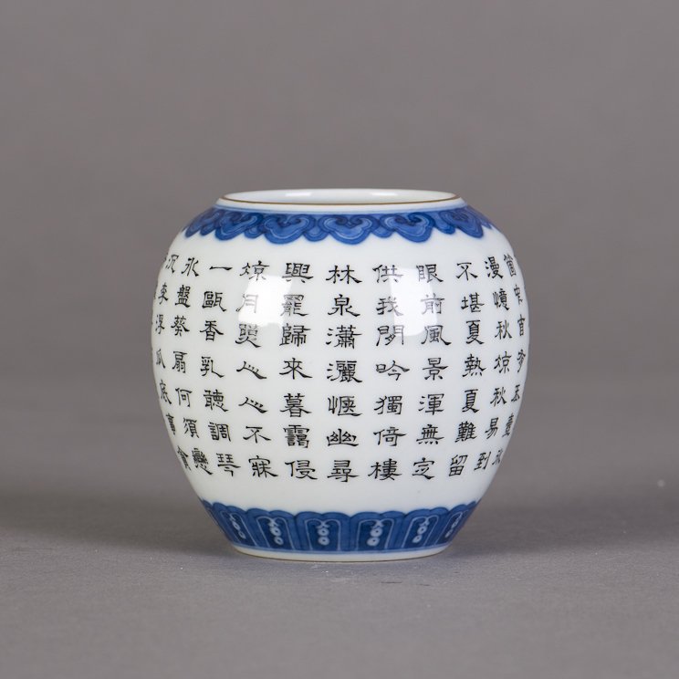 A CHINESE BLUE AND WHITE PORCELAIN BRUSH POT: A Chinese blue and white porcelain brush pot, rounded sides rising to the mouth rim, decorated with bands of scrolling waves near the mouth rim and foot ring, featuring Chinese calligraphy verses with