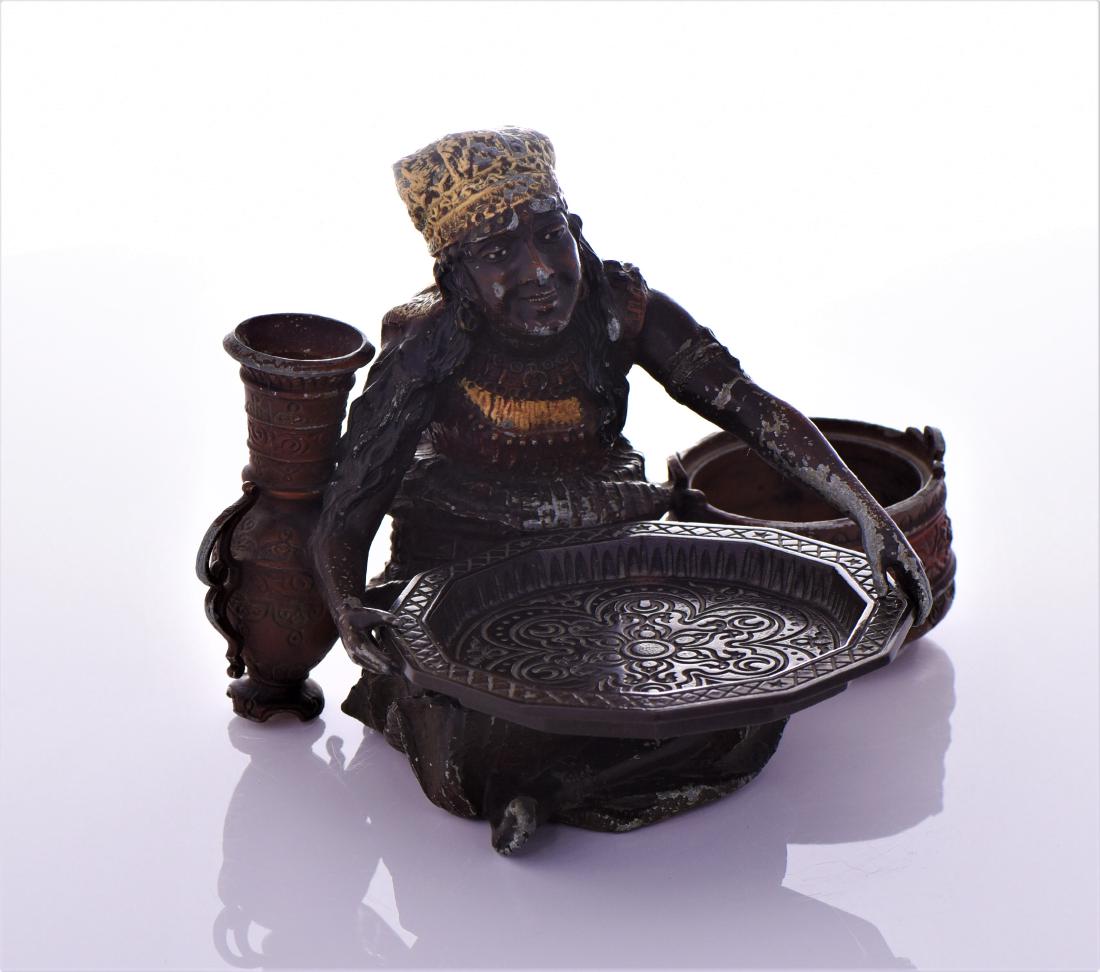 Egyptian Hand Painted Alloy Sculpture Of a Seated: Egyptian Hand Painted Alloy Sculpture Of a Seated Woman Working In a market. She is holding a tray and has a basket and vase by her side. Estimated more than 75 yrs. old. Size and/or Weight: See Measu