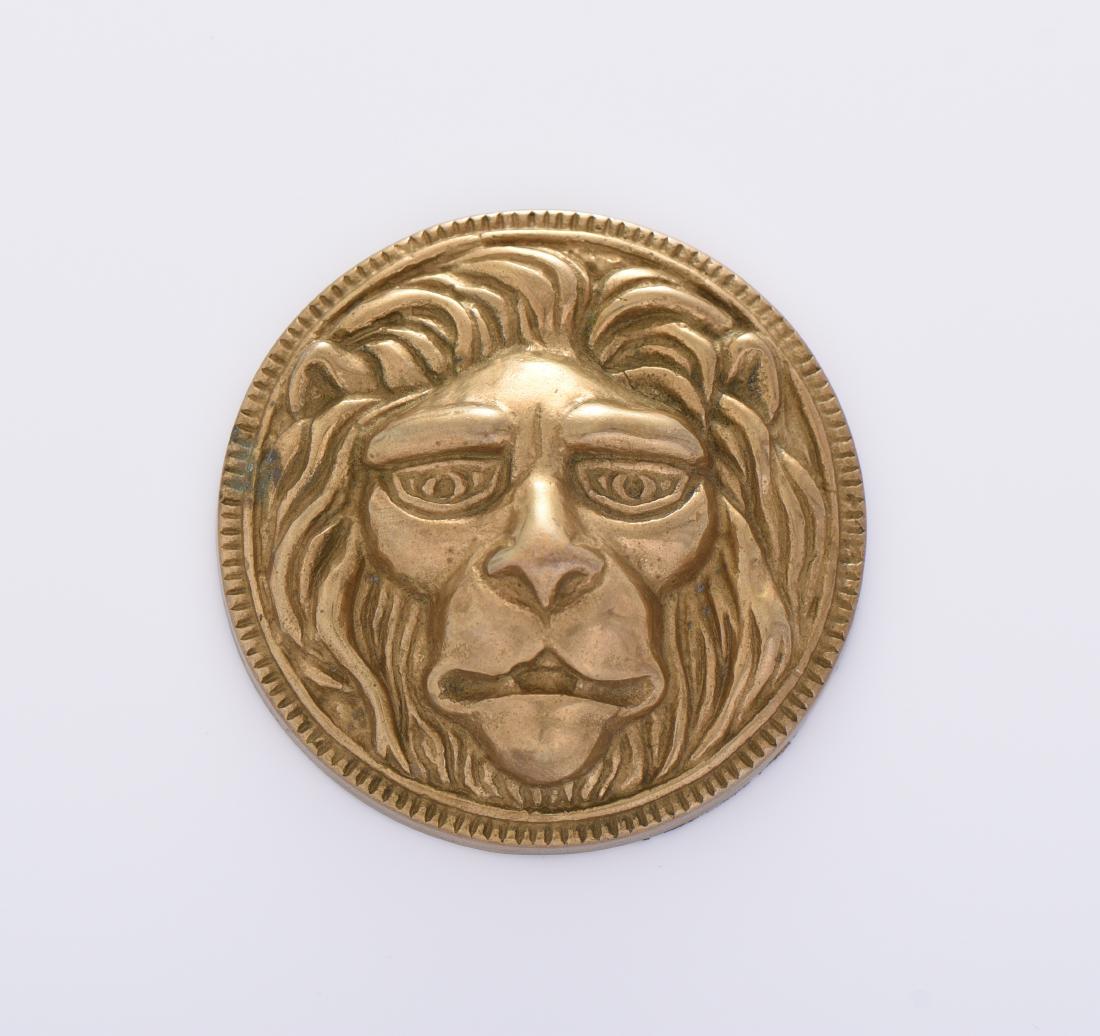 Brass Lion Head Paper Weight Medallion.: Brass Lion Head Paper Weight Medallion. Estimated more than 75 yrs old. Brass is a metallic alloy that is made of copper and zinc. The proportions of zinc and copper can vary to create different types