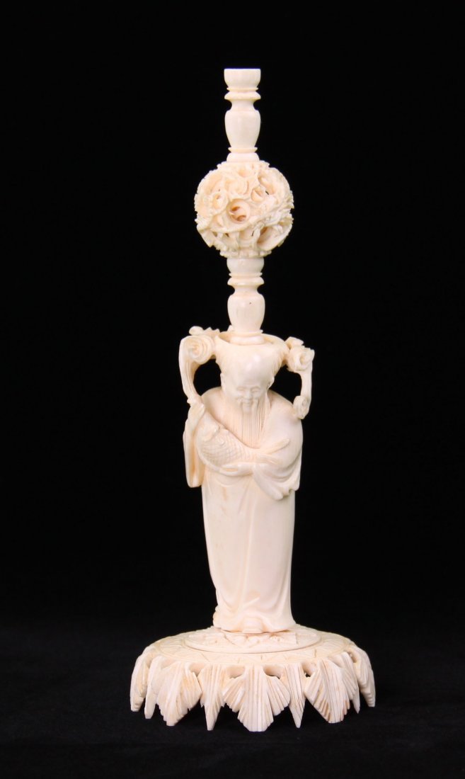 Ivory Magic Ball stand atop of man with holding fish.: Ivory Magic Ball stand atop of man with holding fish. The magic ball has multiple layers and is a Chinese puzzle. Condition Report: A small piece of the intricately carved base is broken. (Size: See l