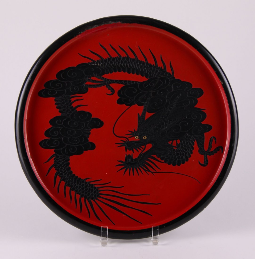Asian black lacquered Dragon charger with exquisite: Asian black lacquered Dragon charger with exquisite layering detail and yellow piercing eyes. Condition Report: Old repair on inner rim and aged crack. SIZE: see attached ruler photo. Photos are part 