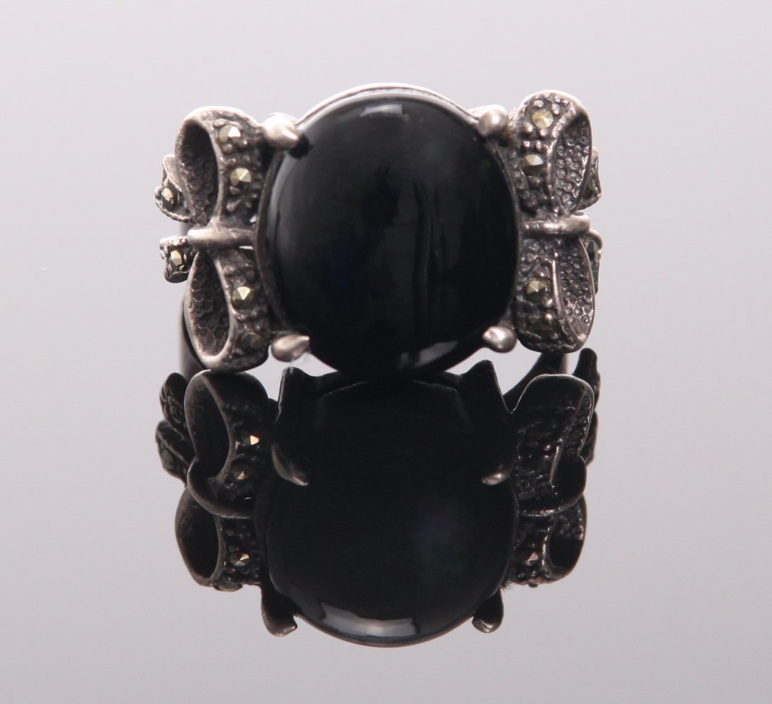 Sterling silver ring with large onyx center stone and m: Sterling silver ring with large onyx center stone and marcasite stones. SIZE: see attached ruler photo. Photos are part of the description representing the condition report and can be used for authent