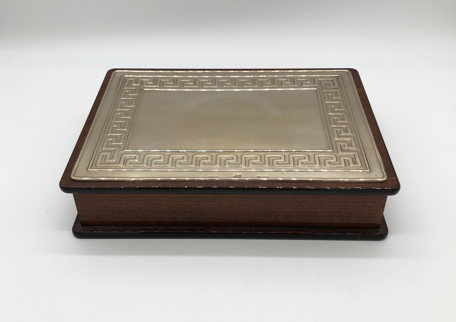 Schatulle, Gianni Versace.: Holz. Deckel mit 925/000 Sterlingsilber-Platte mit reliefiertem Mäanderband. Kratzer. Gem. Gianni Versace, "GB 134", 20. Jh. 7x 31x 23 cm.
