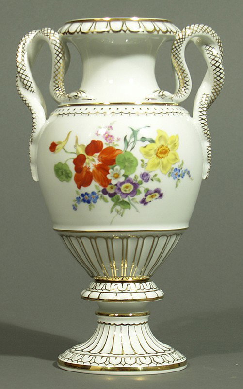 Schlangenhenkelvase, Meissen.: Auf reliefiertem Akanthusfuß balusterförmiger Korpus, schau- und rückseitig mit bunter Blumenbemalung. Goldränder und -staffage. Handhaben in Form sich windender Schlangen. Blaue Schwertermarke Me