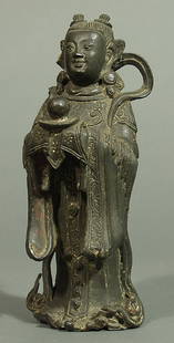 Stehender Adorant.: Bronze mit schwärzlicher Patina. Die Figur hält einen Teller mit dem Wunschjuwel in beiden Händen. Das Gewand mit feiner Gravur. Reste alter Rotlackbemalung, das Wolkenband mit Ausbruch. China, 18.