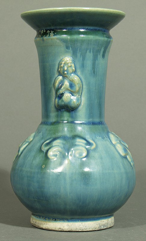 Vase.: Keramik mit verlaufender Glasur in Blau. Keulenform, mit aufgelegten Blüten und Buddhas. Wohl Korea, Anf. 20. Jh. H. 20 cm.