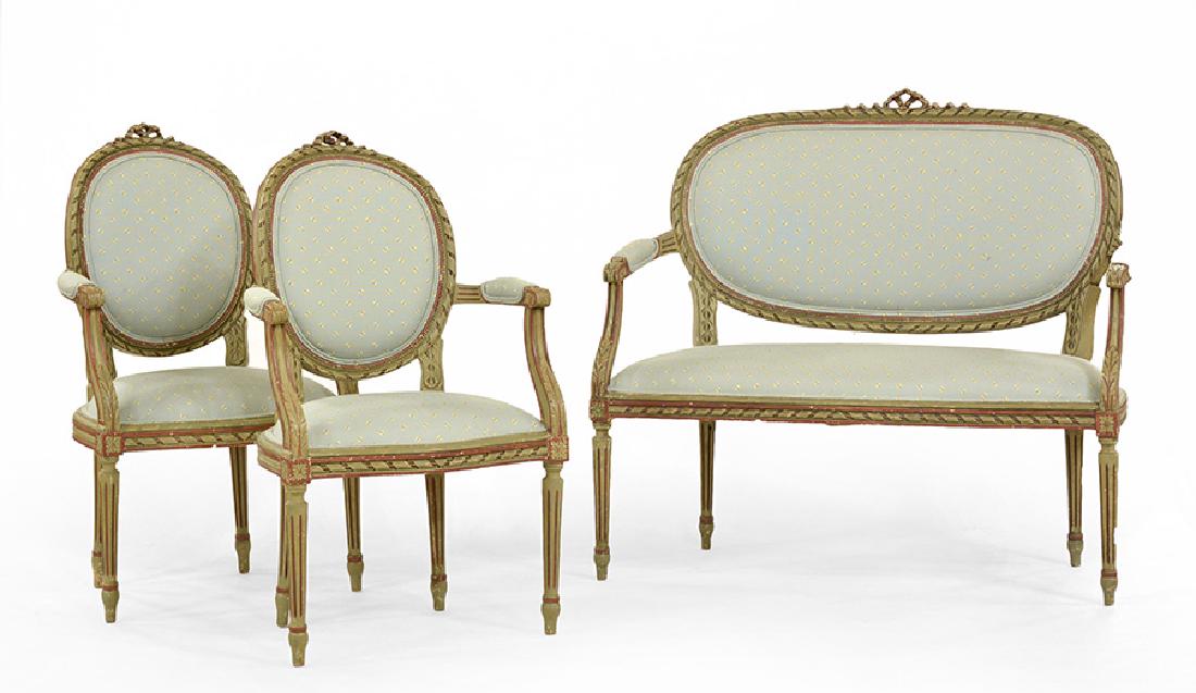 LOUIS XVI STYLE: Louis XVI style Set of 2 armchairs and a couch in painted carved wood with foliage decor, resting on tapered legs. Seating and backrest upholstered in green blue fabric with bee patern. Dimensions cha
