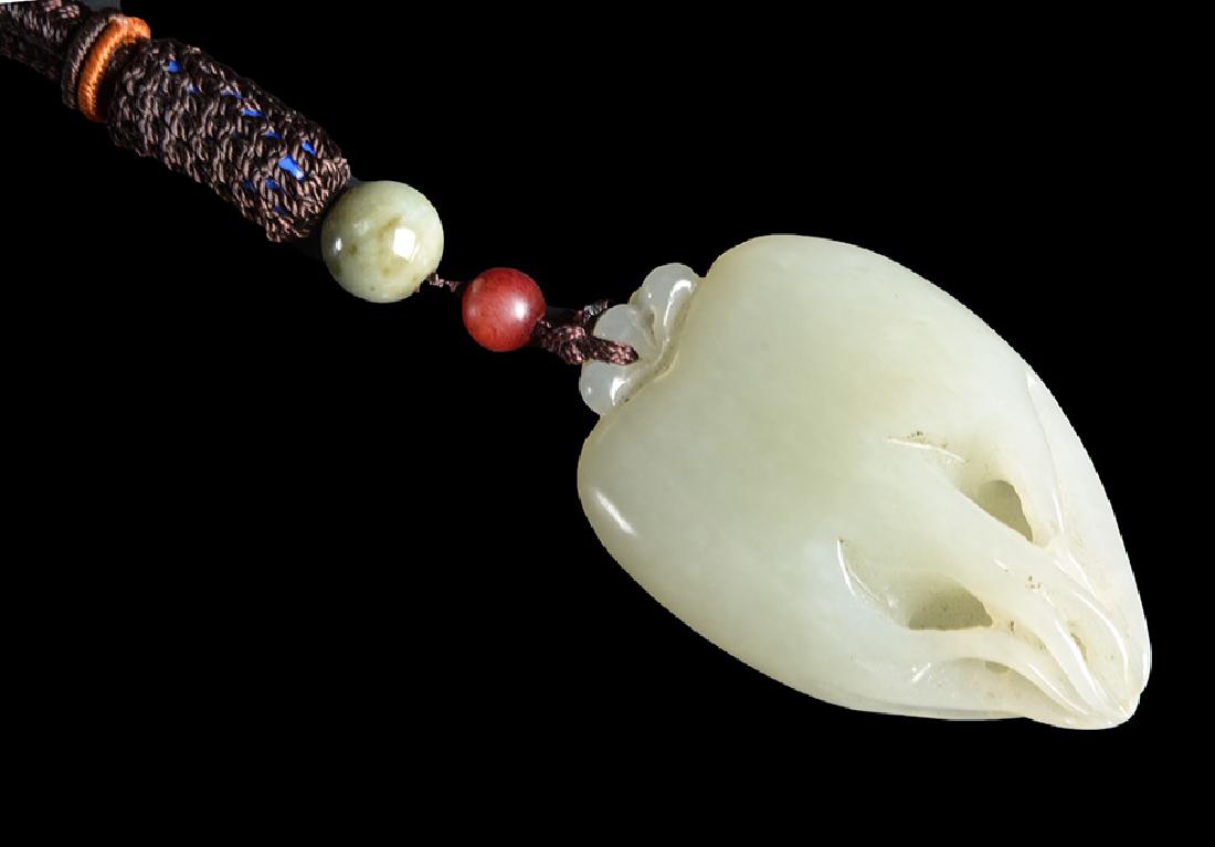 CHINA, 20th C.: Celadon jade pendant carved in the shape of a digitized lemon. China, 20th C. H: 5.5cm - 2.25" L: 3.25cm - 1.25" D: 1.5cm - 0.5"