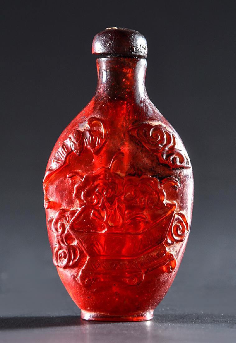 CHINE / CHINA: CHINE Tabatière en résine synthétique ambrée sculptée de chauves-souris volant au-dessus d'un vase à fleurs et d'une jardinière à bonsaï. Sceau gravé. Chine, XXe siècle. H: 7.5cm - 3" Engli