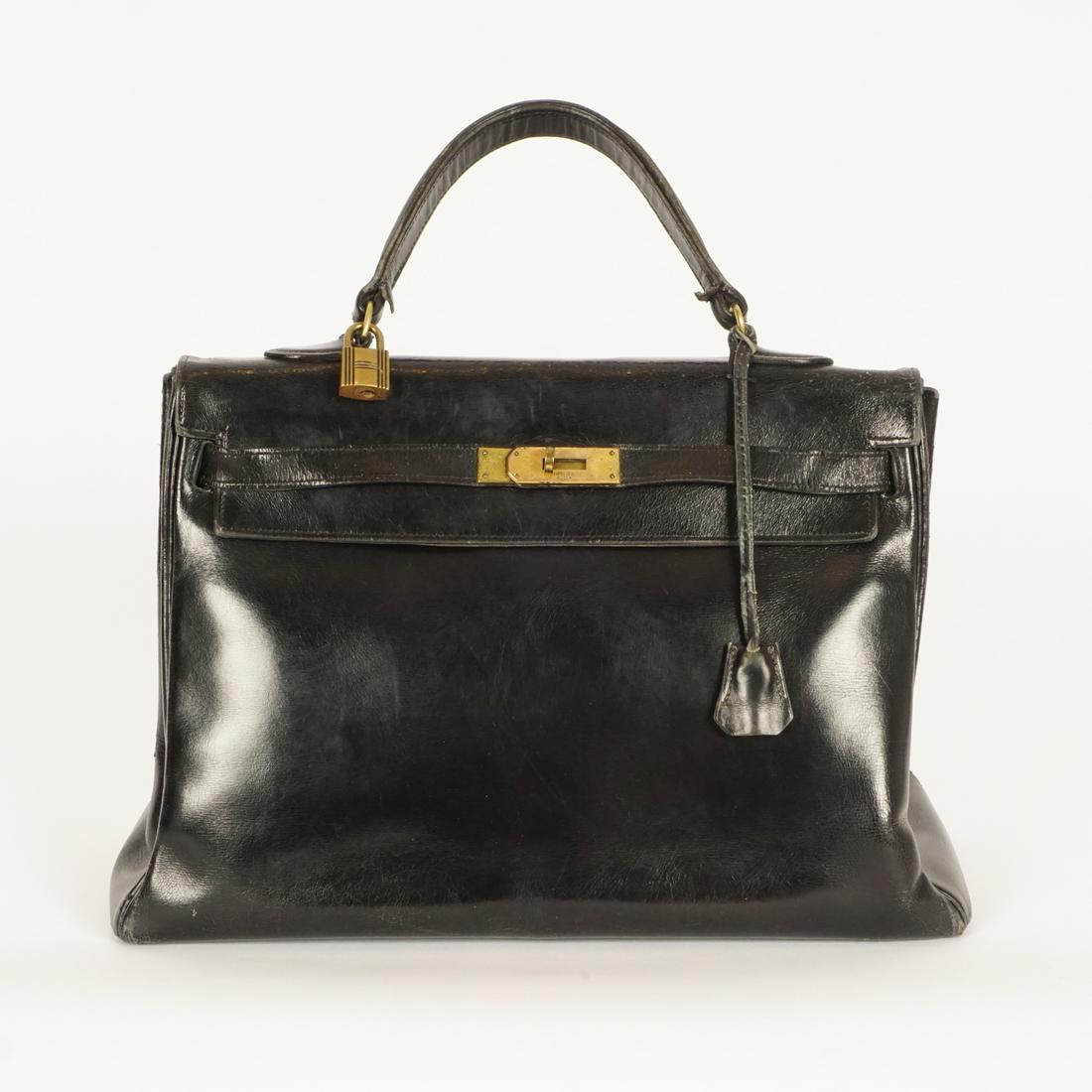 HERMÈS, KELLY: Description française: HERMÈS, SAC KELLY Iconique sac à main Kelly 35 datant des années 50, cuir noir « box calf » lisse, avec cadenas, clés et cloche original. Cout