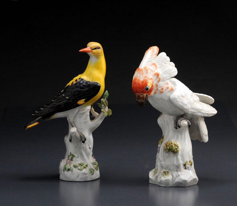 Lot of two porcelain sculptures of birds, one fe: Lot of two porcelain sculptures of birds, one featuring a cacatoes. Germany, 20th century. Blue crossed swords mark on the bottoms. H (the biggest): 25.5cm – 10”