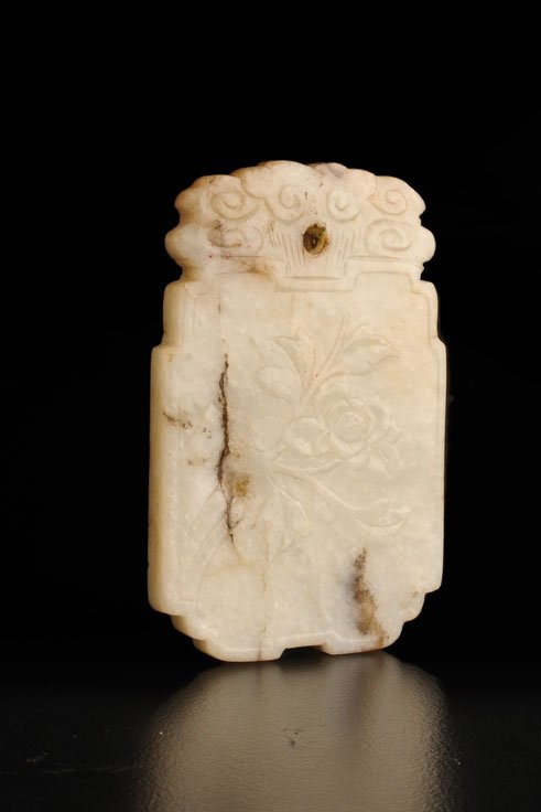 ANTIQUE WHITE JADE PENDANT PLAQUE - Westmount: PROPERTIES OF A WESTMOUNT COLLECTOR, QUEBEC (LOTS 2005-2026) Antique white JADE pendant carved with chrysanthemum on a face and with a four-character inscription on the other. China. H : 5cm – 2’�