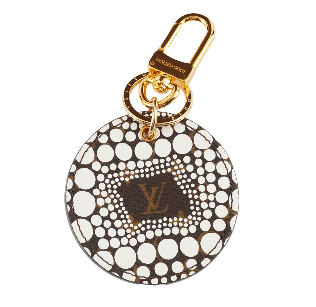 LOUIS VUITTON x YAYOI KUSAMA: Description française: LOUIS VUITTON x YAYOI KUSAMA Porte-clés et bijou de sac Louis Vuitton x Yayoi Kusama en toile monogrammée à pois infinis blancs D: 6.5 cm - 2.75" English Des
