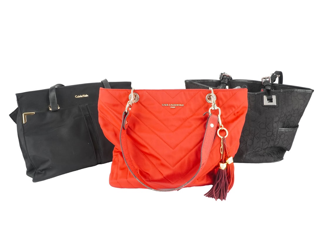 CALVIN KLEIN / KARL LAGERFELD: Description française: CALVIN KLEIN / KARL LAGERFELD Deux sacs Calvin Klein en toile noir et un sac Carl Lagerfeld en toile rouge. English Description: CALVIN KLEIN / KARL LAGERFELD Two Calvin Kl