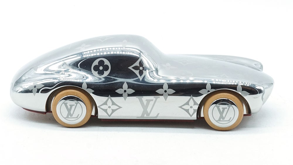 LOUIS VUITTON: Description française: LOUIS VUITTON Presse-papier Louis Vuitton Voguez Volez finition argentée et garni de cuir sous la base. Dimensions : 5 x 15 x 6 cm English Description: LOUIS VUITTON L