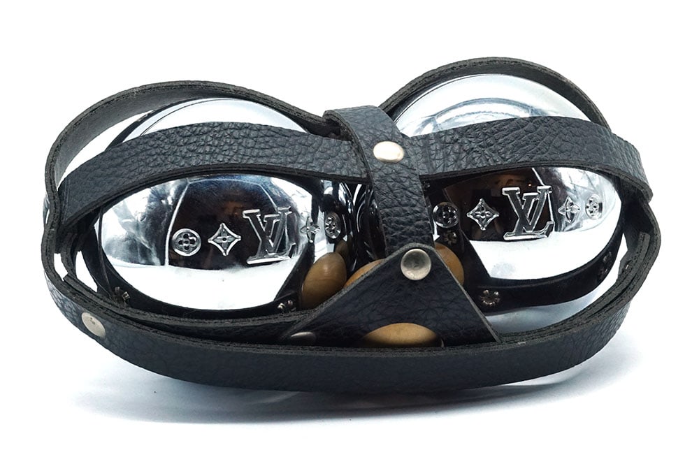LOUIS VUITTON: Description française: LOUIS VUITTON Jeu de pétanque Louis Vuitton à pétanques en cuir noir comportant 2 boules et 1 cochonnet. Mention "Monaco 2003" sur les boules. English