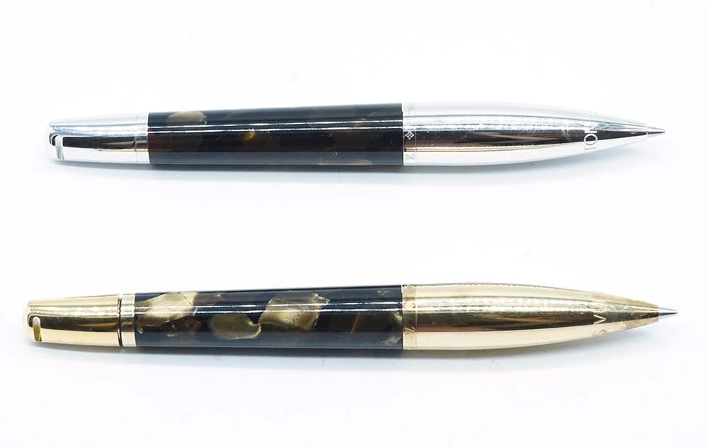 LOUIS VUITTON: Description française: LOUIS VUITTON Ensemble de 2 stylos à bille Louis Vuitton, l'un avec finition argentée, l'autre finition dorée. Mines rétractables (système