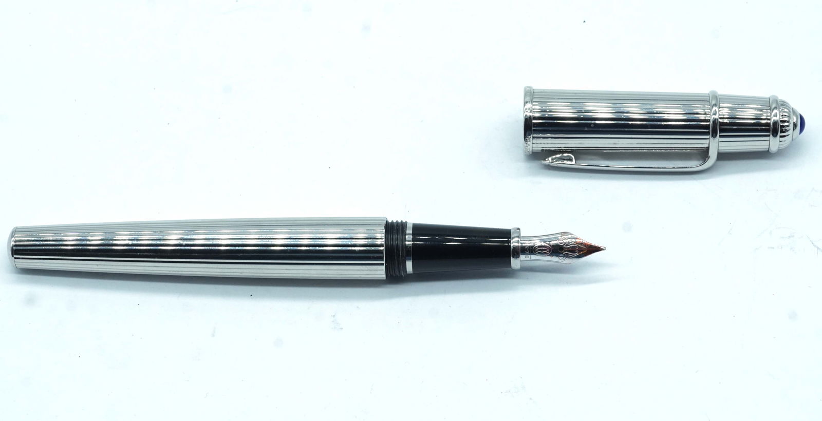 CARTIER "DIABOLO PLATINUM": Description française: CARTIER "DIABOLO PLATINUM" Stylo à plume Cartier "Diabolo Platinum", numéroté 027015, décor à rayures et capuchon orné d'une pierre bleue. Plu