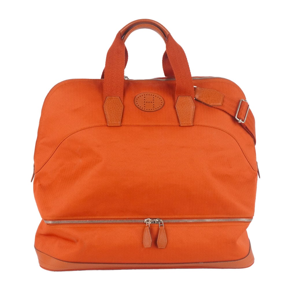 HERMÈS GOLF 47: Description française: HERMÈS GOLF 47 Sac de voyage Hermès Golf 47 en toile orange et finition en cuir, deux poignées en cuir roulées, une bandoulière détachable,