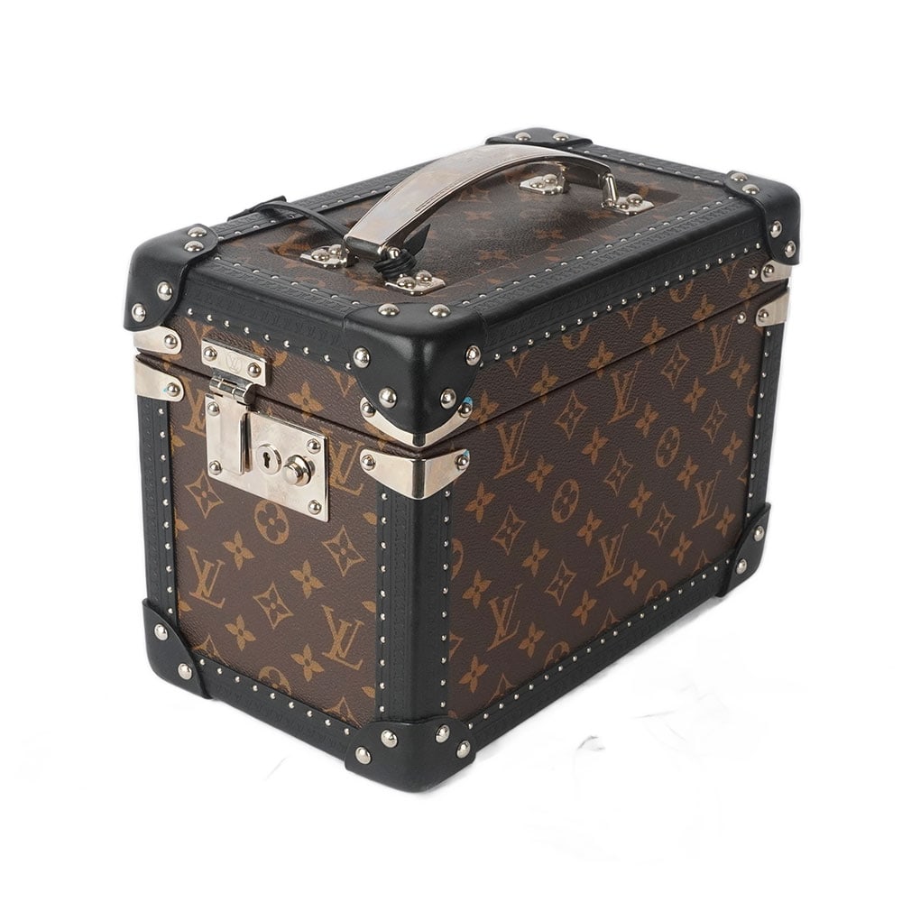 LOUIS VUITTON: Description française: LOUIS VUITTON Boîte à trésor Louis Vuitton en toile Monogram et cuir noir, garniture en métal argenté, doublure lavable, clées incluses, num&#