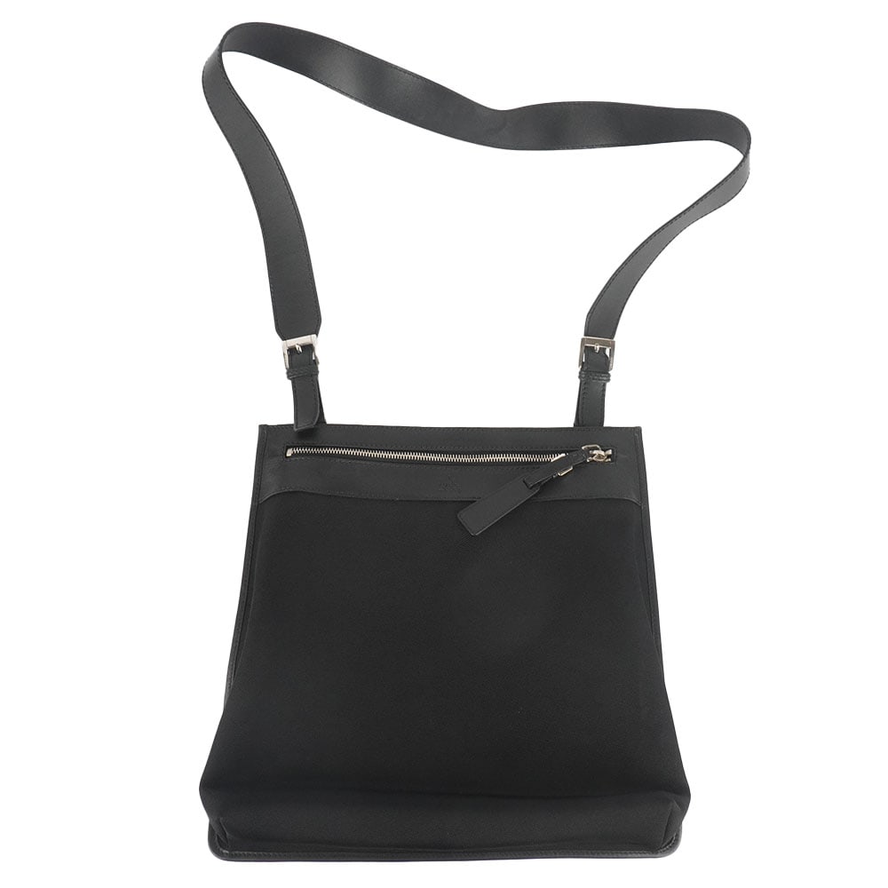 GUCCI: Description française: GUCCI Sac Messenger Gucci en toile et cuir noir, une poche zippéée intérieure, une bandoulière en cuir noir. H: 30 cm - 11.75", L: 28 cm - 11", P: 4 cm