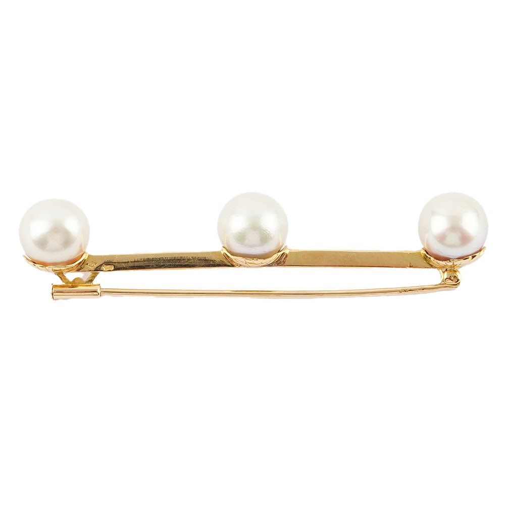 OR 18K, PERLES / 18K, PEARLS: Description française: OR 18K, PERLES / 18K GOLD, PEARLS Broche en or jaune 18K, ponçon " tête d'aigle" ornée de 3 perles de 9.1 mm environ. Poids brut: 6.0 g Longueur: 6 cm -