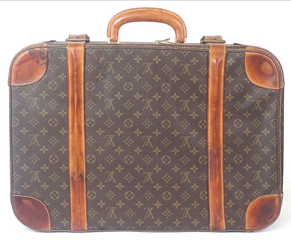 LOUIS VUITTON: Description française: LOUIS VUITTON Valise Louis Vuitton en toile enduite monogrammée et cuir naturel, fermeture à zip et boucles à sangles. Doublure en satin beige, pochettes
