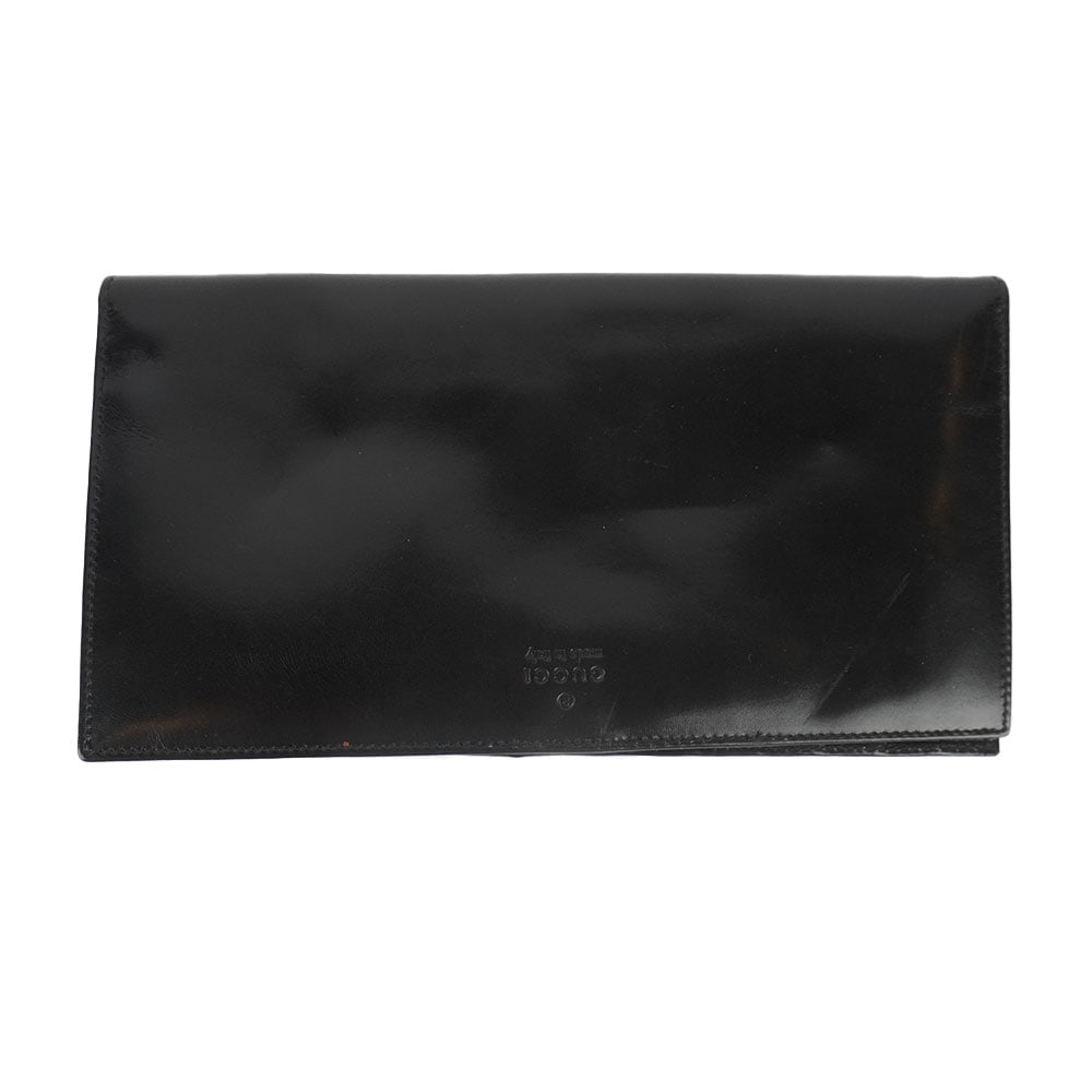 GUCCI: Description française: GUCCI Pochette de voyage Gucci en cuir noir laqué, fermeture par bouton de pression, compartiments pour des billets d'avion, cartes, monnaies et autres . H: 11 cm - 45