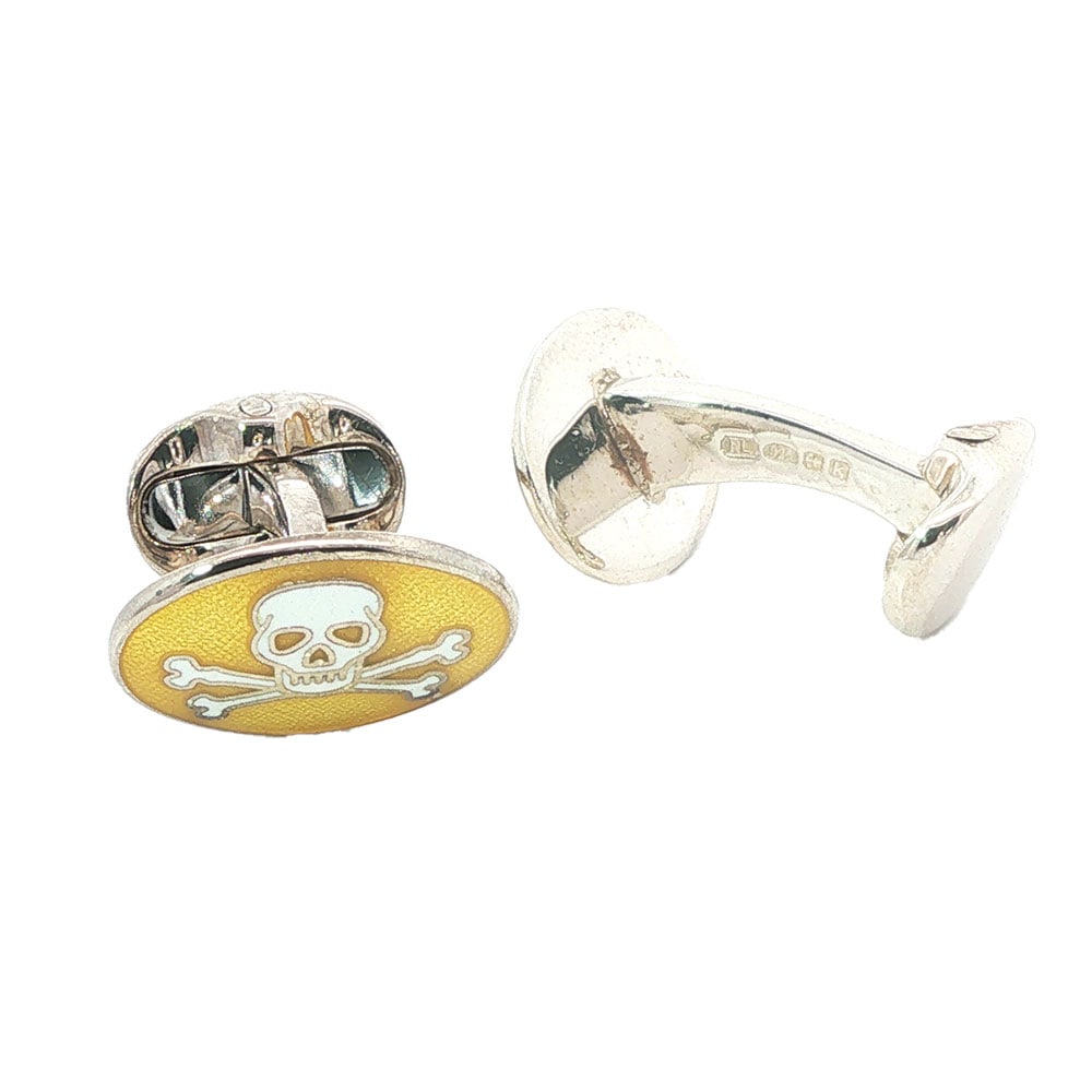 BOUTONS DE MANCHETTE /CUFFLINKS: Description française: BOUTONS DE MANCHETTE / CUFFLINKS Boutons de manchette en argent 925 stylisant des têtes de mort sur émail jaune, signé RL, poinçon anglais English Descr