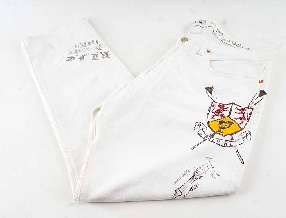 POLO RALPH LAUREN: Description française: POLO RALPH LAUREN Pantalon blanc à dessins colorés et inscriptions. Taille 36. English Description: POLO RALPH LAUREN White trousers with colorful designs and