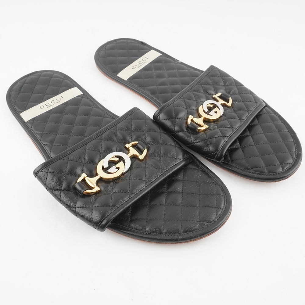 GUCCI: Description française: GUCCI Pantoufles Gucci en cuir noir, logo GG en métal doré. Étui de voyage. Taille 9 homme. English Description: GUCCI Pantoufles Gucci en cuir noir, logo