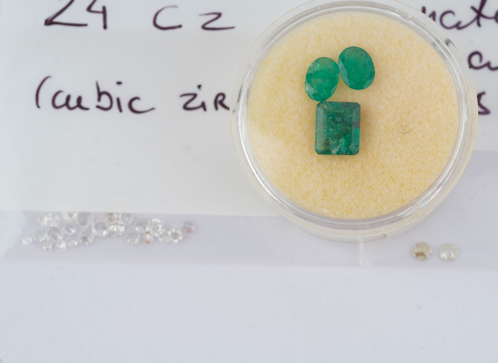 GEMMES: Description française: GEMMES Lot comprenant: - 3 émaraudes naturelles traités pesant au total 2.0 ct environ - lot de cubic zirconium - deux diamants taille rond brillant de 2.5 mm